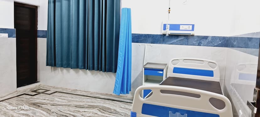 Clean patient ward with hospital bed and blue curtain partitions